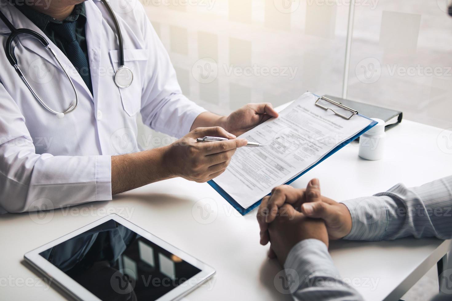 el médico está escribiendo la carta de cita al paciente en la clínica. foto