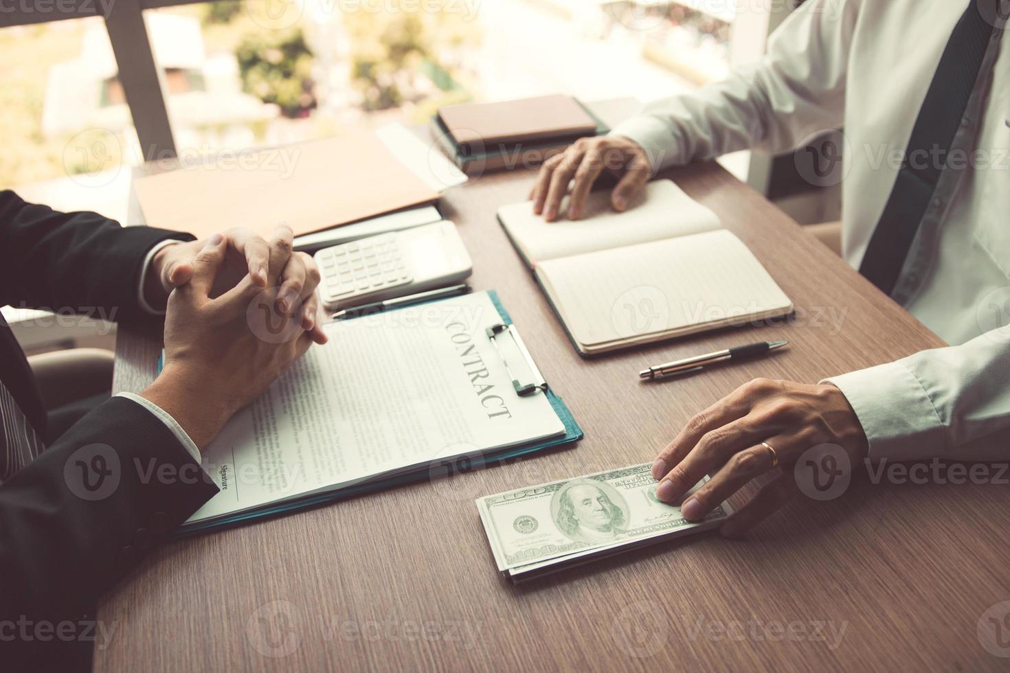 Partner has made a fraud in the contract of sale and being handed a cash and pen to the businessman signing the contract corruption bribery concept. photo