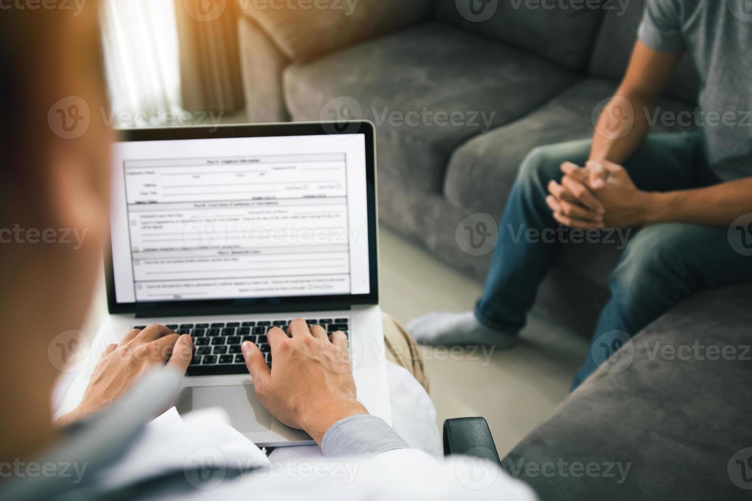 el médico está usando una computadora portátil mientras escribe el historial personal del paciente y da consejos sobre el tratamiento en el hogar del paciente. foto