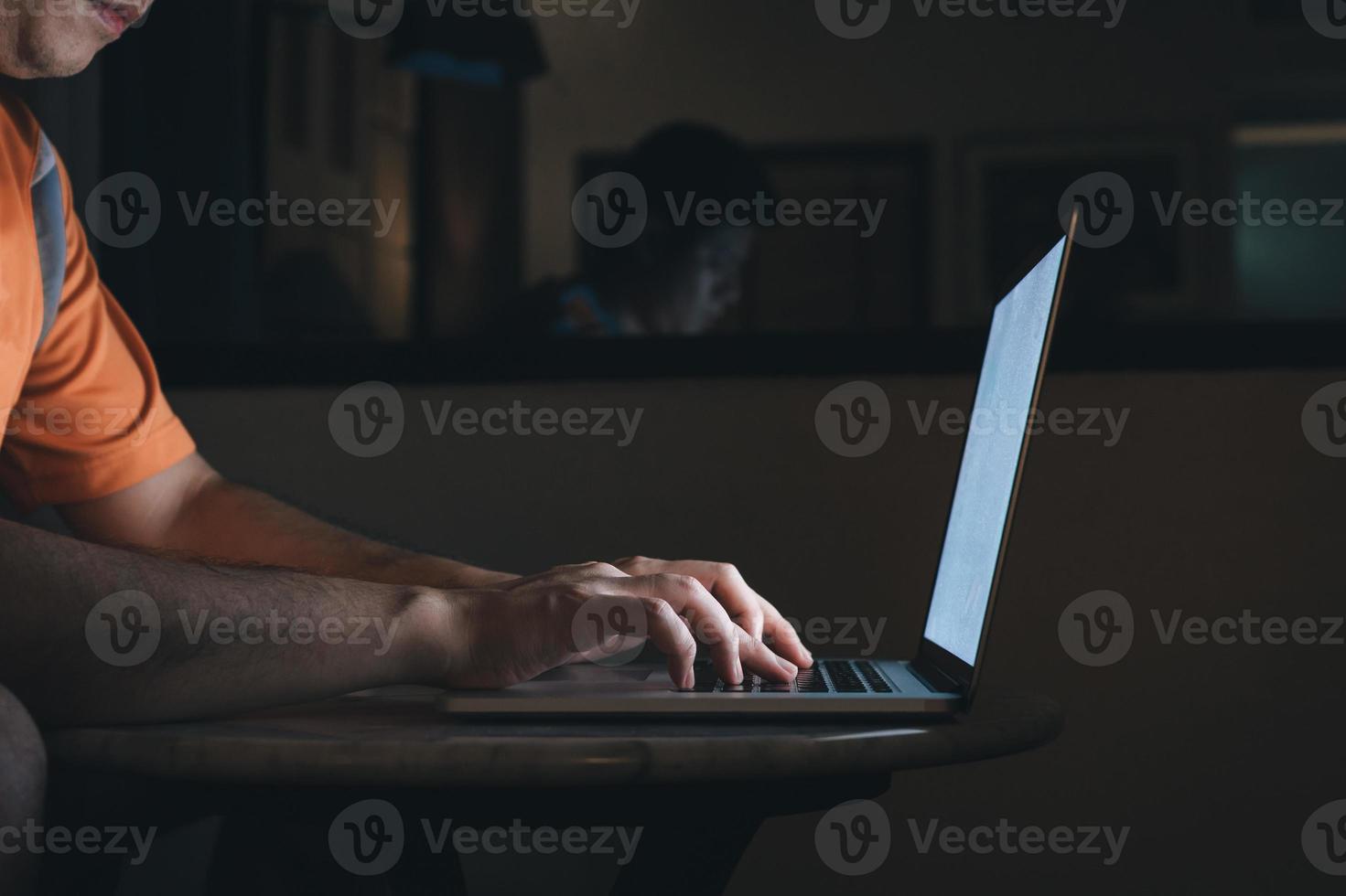 Man typing on keyboard and working at computer laptop in night. photo