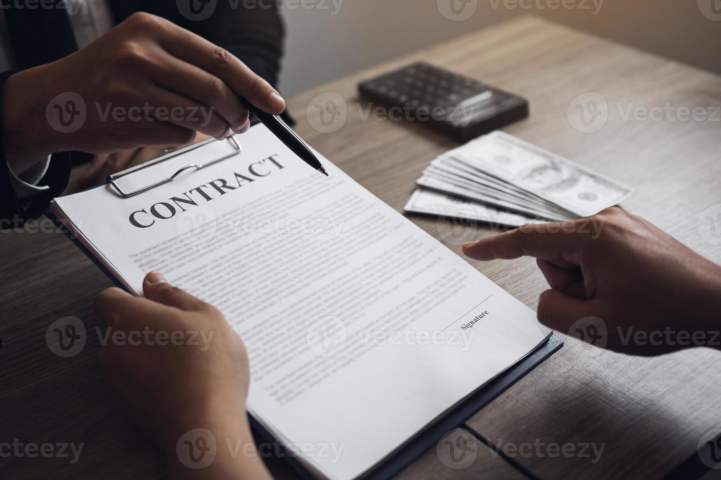 agentes inmobiliarios hablando con compradores de viviendas que están firmando contratos en la oficina. foto