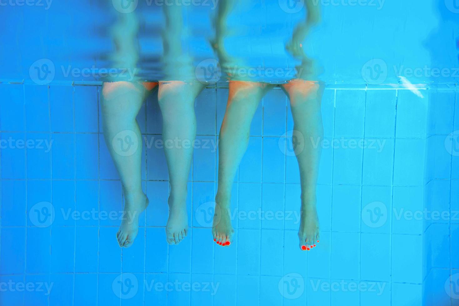 two people legs underwater in the swimming pool. Party. Summer. Vacation, diversity, friendship and sport concept. photo