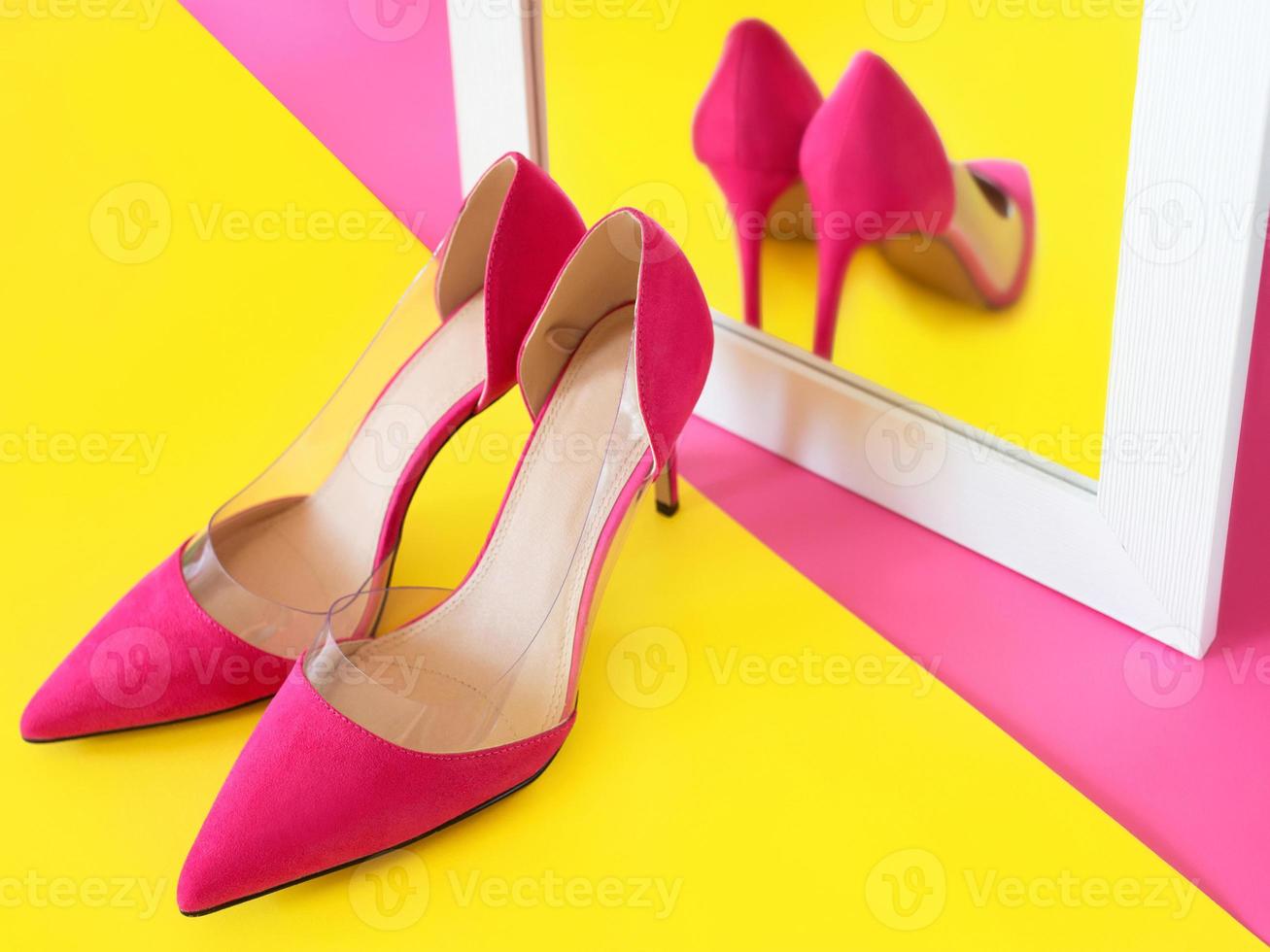 elegantes zapatos de tacón rosa sobre fondo rosa viendo su propio reflejo en el espejo. zapatos, moda, ego, egoísta, narcisismo, estilo, compras, concepto de venta foto