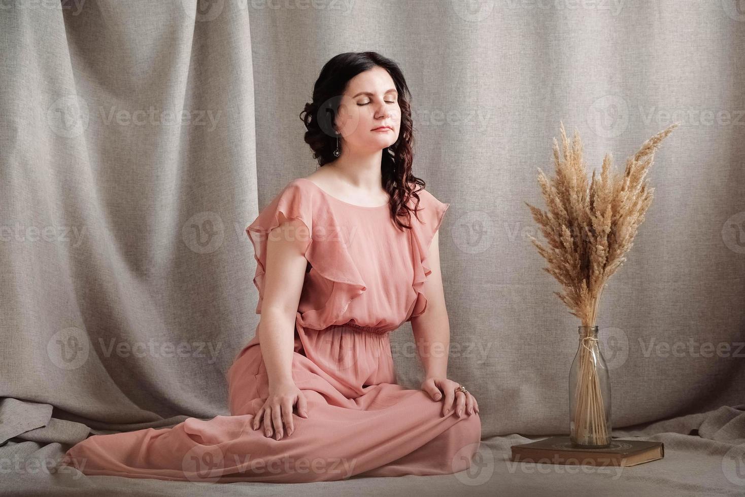 hermosa mujer morena con un vestido rosa sobre un fondo de tela de lino. copiar, espacio vacío para texto foto