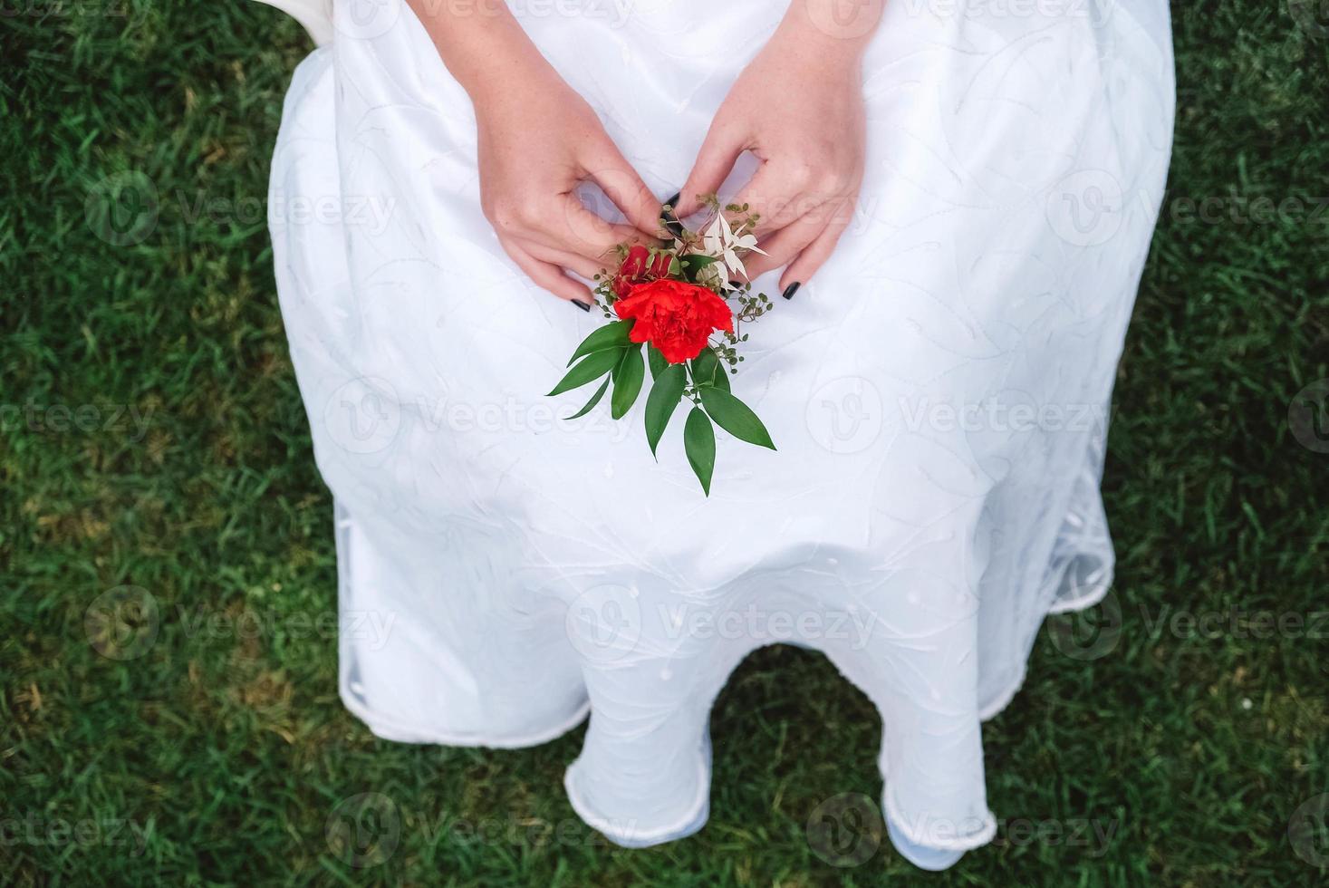 Boutonniere for wedding in the hands of a girl bride in a white dress. Copy, empty space for text photo