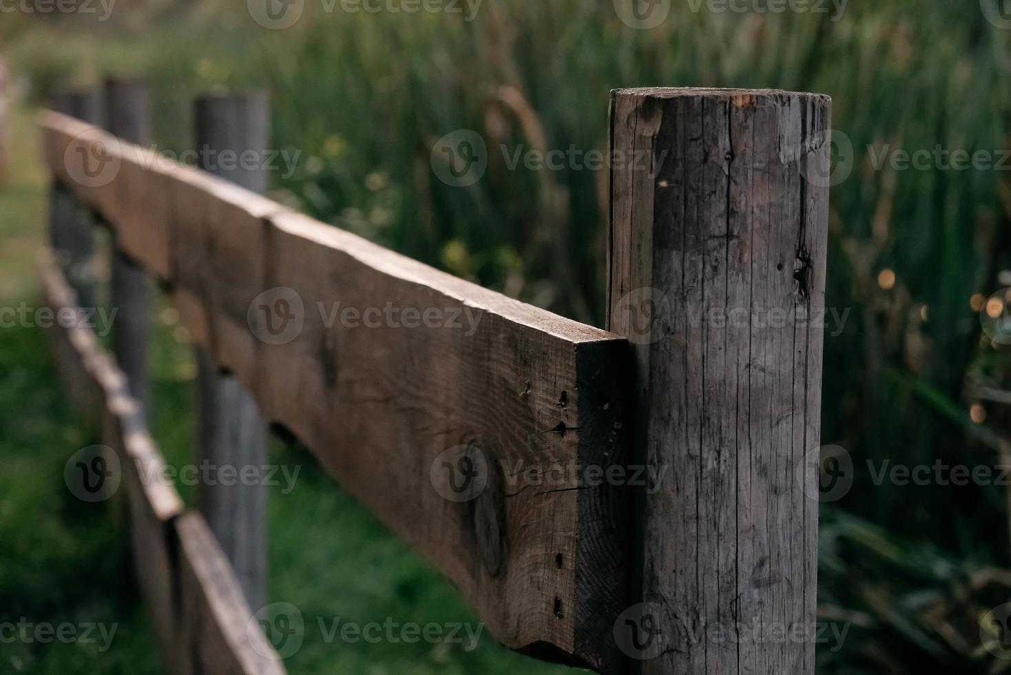 valla rural de madera sobre un fondo de hierba verde foto