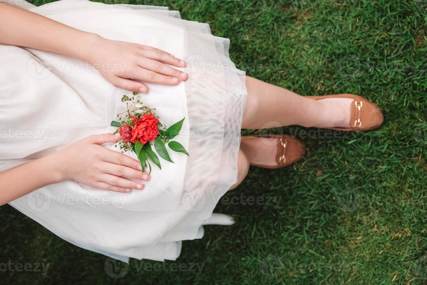 Boutonniere for wedding in the hands of a girl bride in a white dress. Copy, empty space for text photo