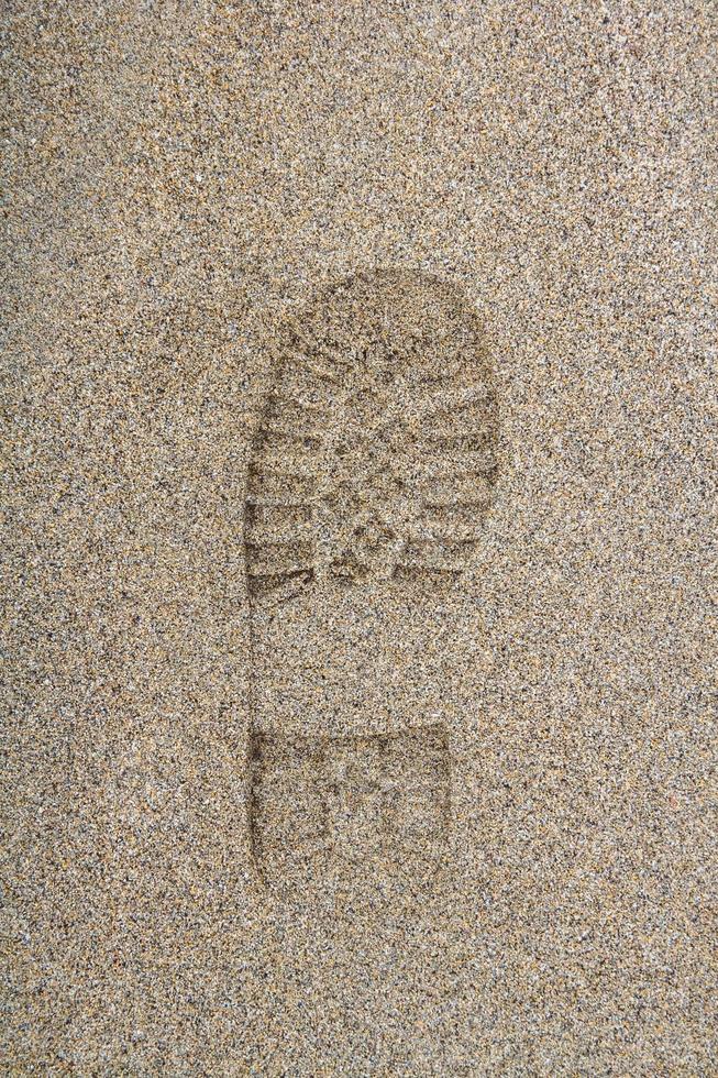 Footprint from a shoe on a sandy surface photo