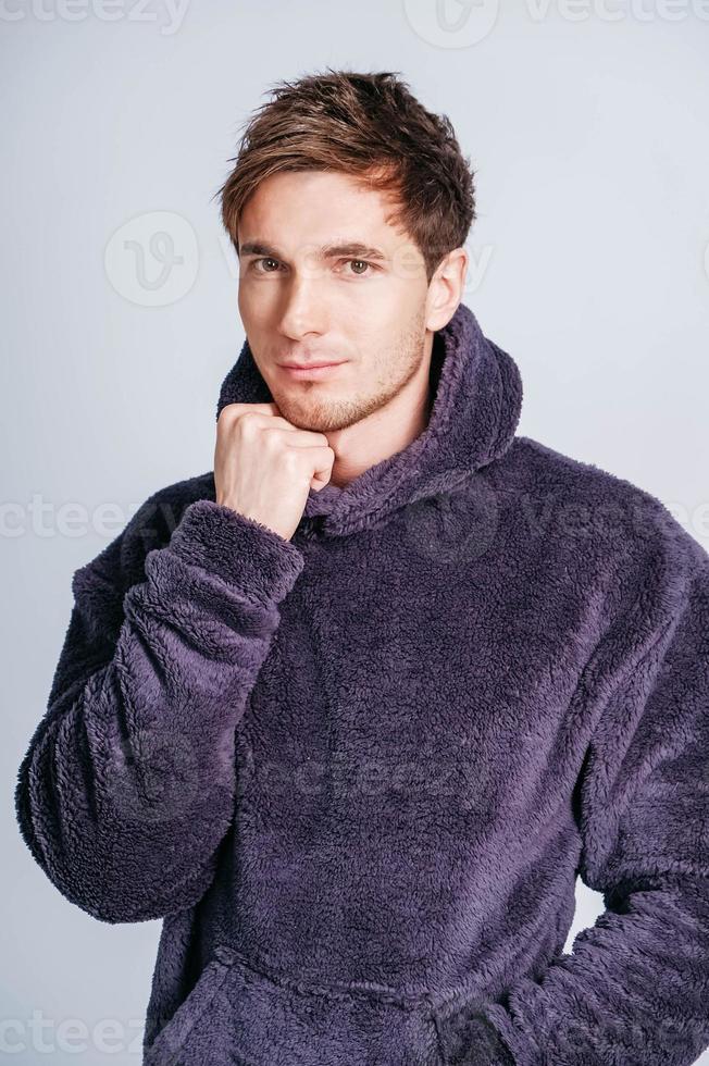 retrato de un joven con sudadera morada con capucha en un fondo blanco. copiar, espacio vacío para texto foto
