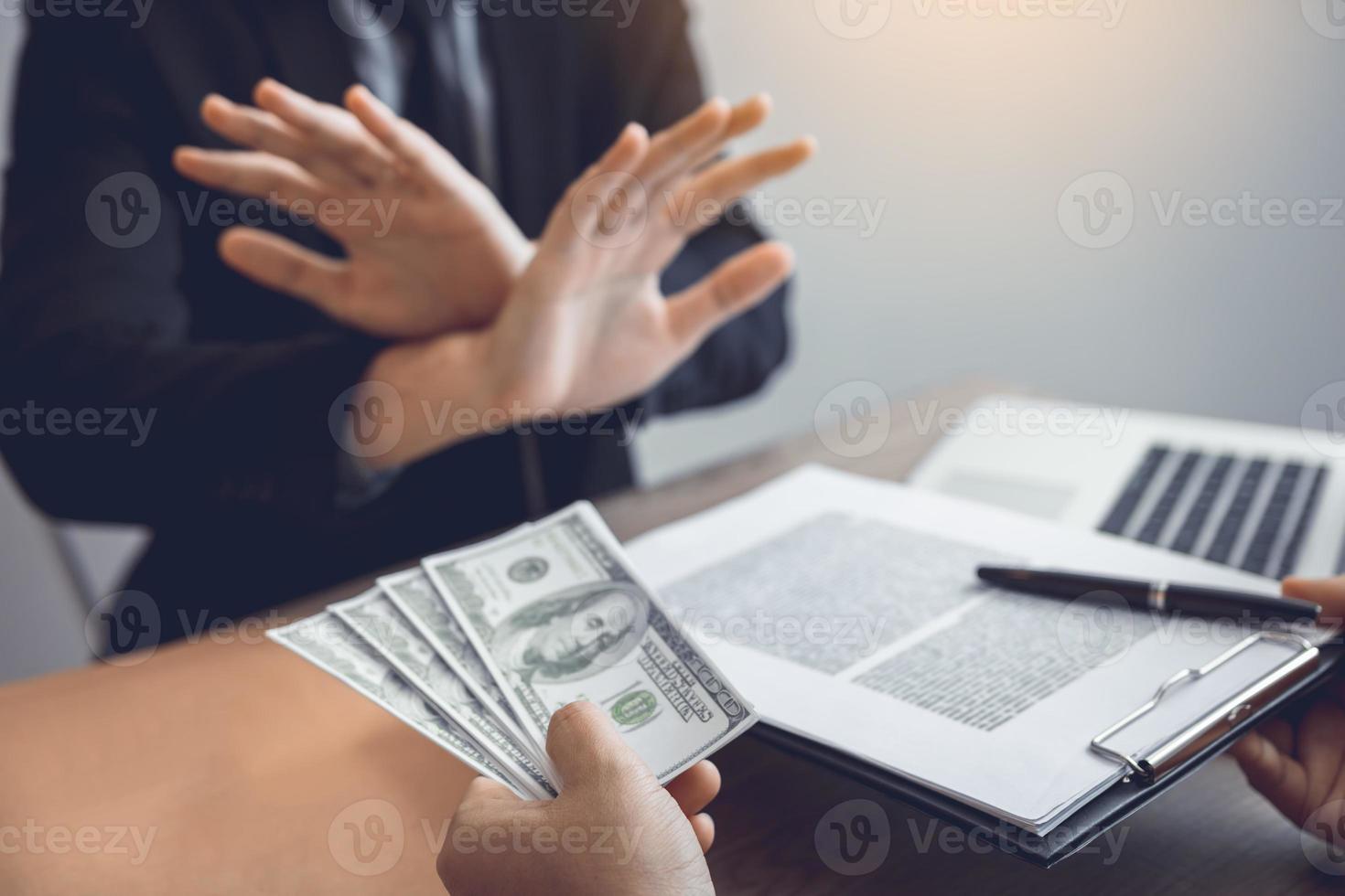 Businessperson refusing bribe given money by partner with anti bribery corruption concept. photo