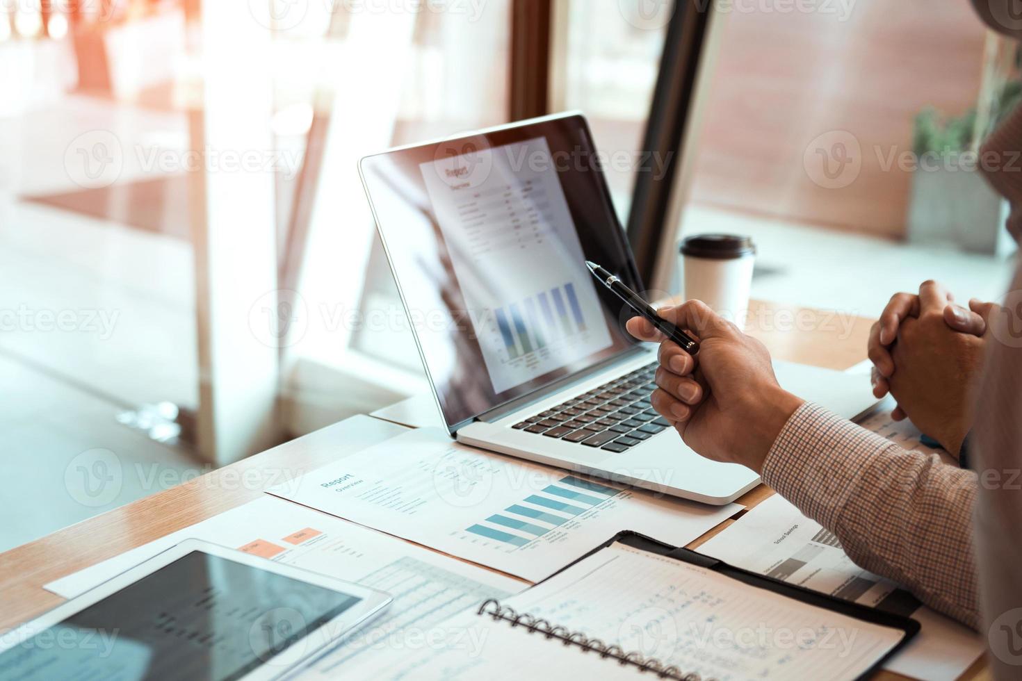 Manager is using a laptop computer while analyzing the company's financial statements on the screen. photo