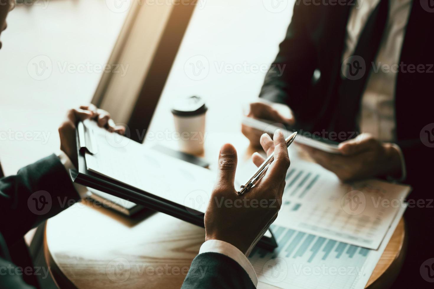 Business partnership coworkers using a tablet to chart company financial statements report and profits work progress and planning in office room. photo