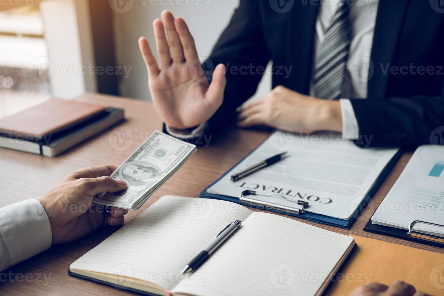 Business person refusing bribe given money by partner with anti bribery corruption concept. photo