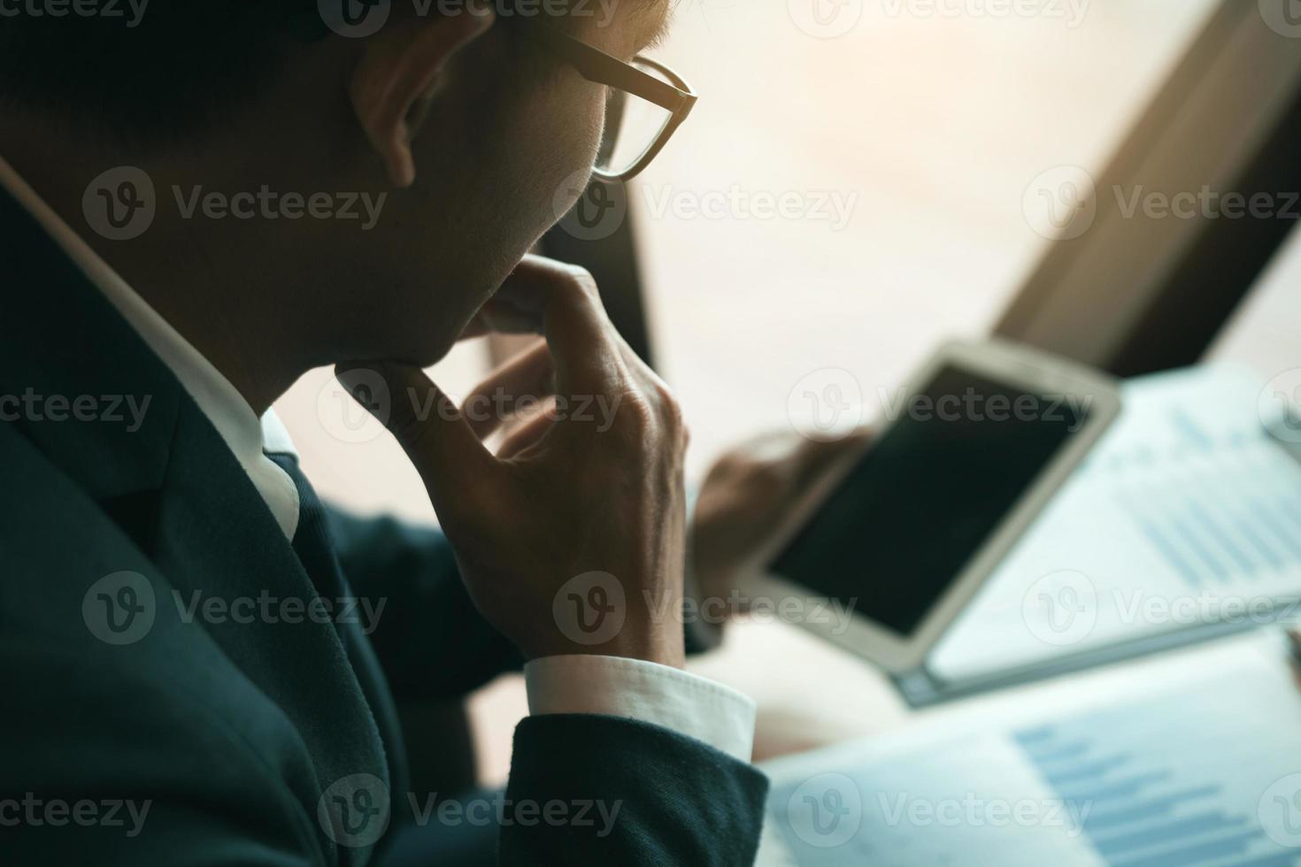 Male manager businessmen are looking at the tablet screen with the company's financial information and he is tense about the performance. photo