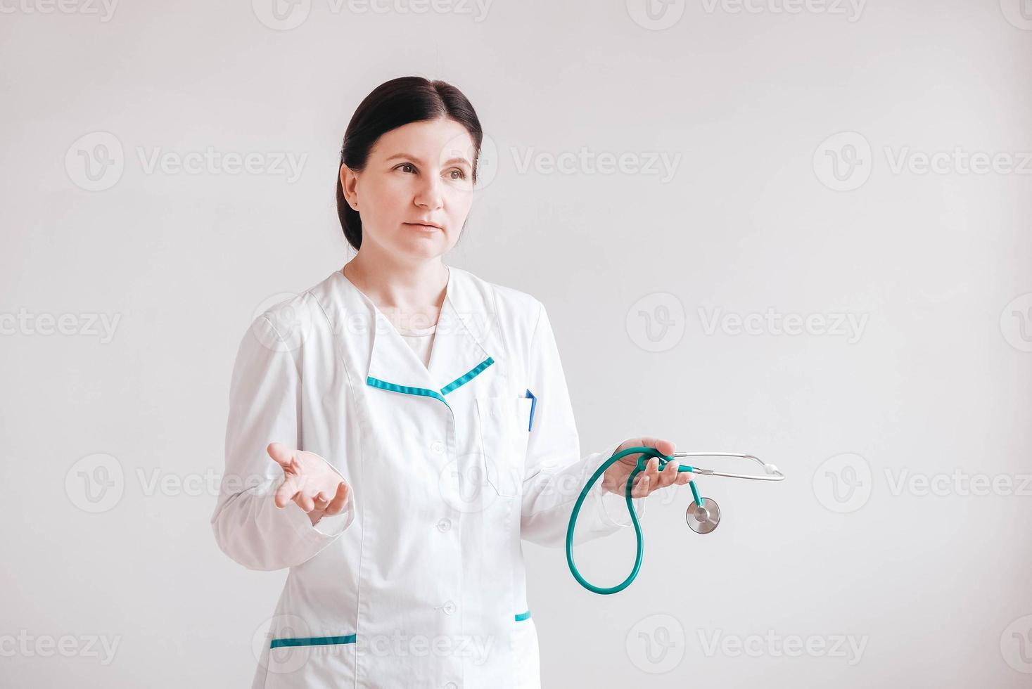 Woman doctor with a stethoscope in his hands on a white background. Copy, empty space for text photo