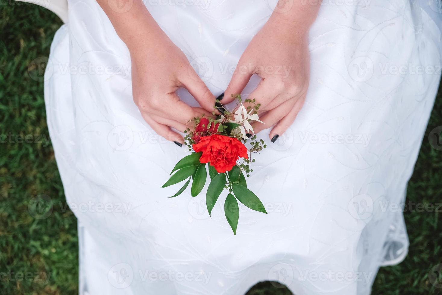 Boutonniere for wedding in the hands of a girl bride in a white dress. Copy, empty space for text photo