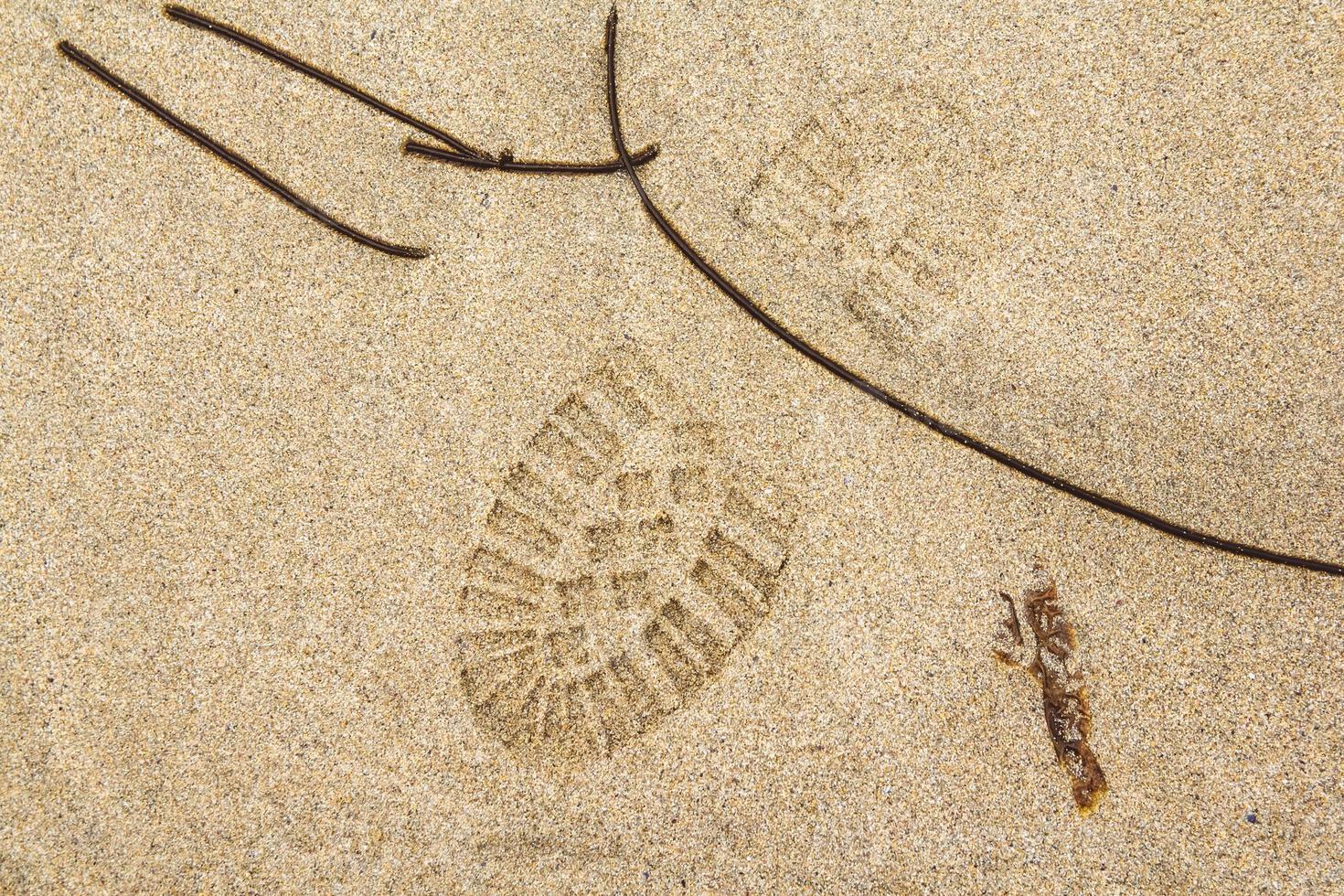Footprint from a shoe on a sandy surface photo