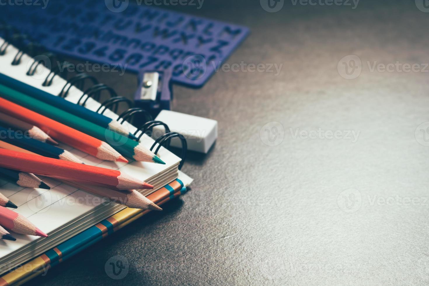 Color pencil on student table and notebook with education concept. photo