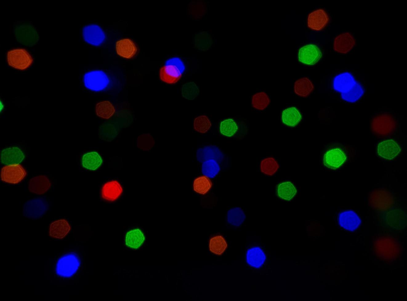 pequeñas imágenes de fondo bokeh que brillan en la noche y muchos colores. foto