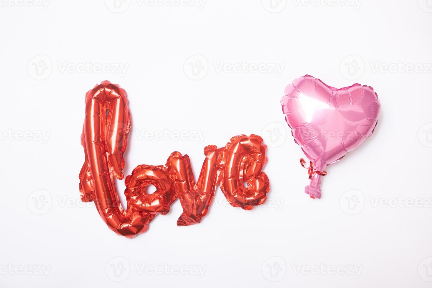 Foil balloon shape heart and love word on white background. Decorations for Valentines or Wedding Day photo