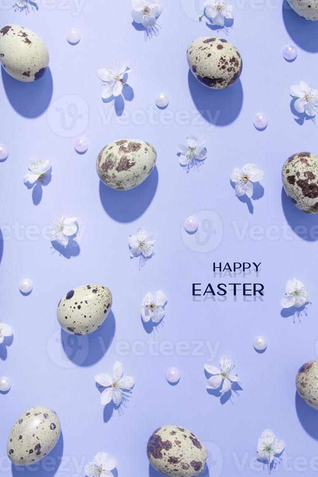 Happy Easter greeting card with top view composition easter eggs and cherry flowers pattern on blue background. Trendy minimal style photo