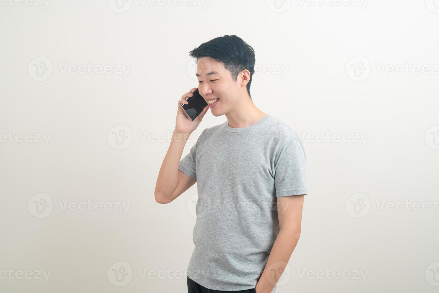 young Asian man using or talking smartphone and mobile phone photo