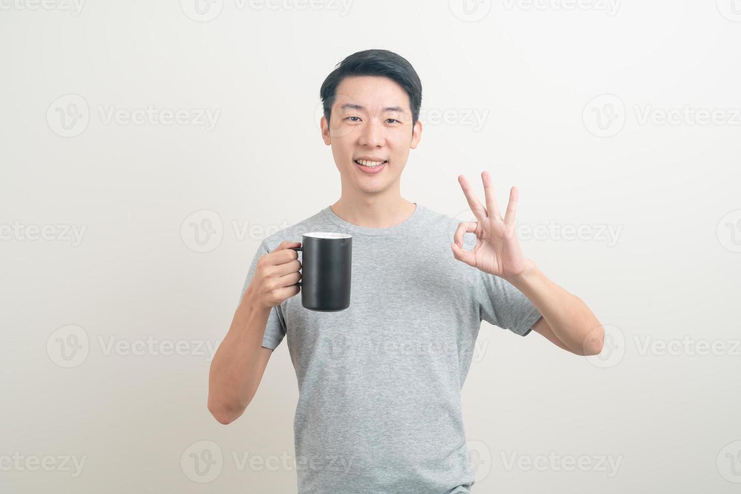 young Asian man holding coffee cup photo