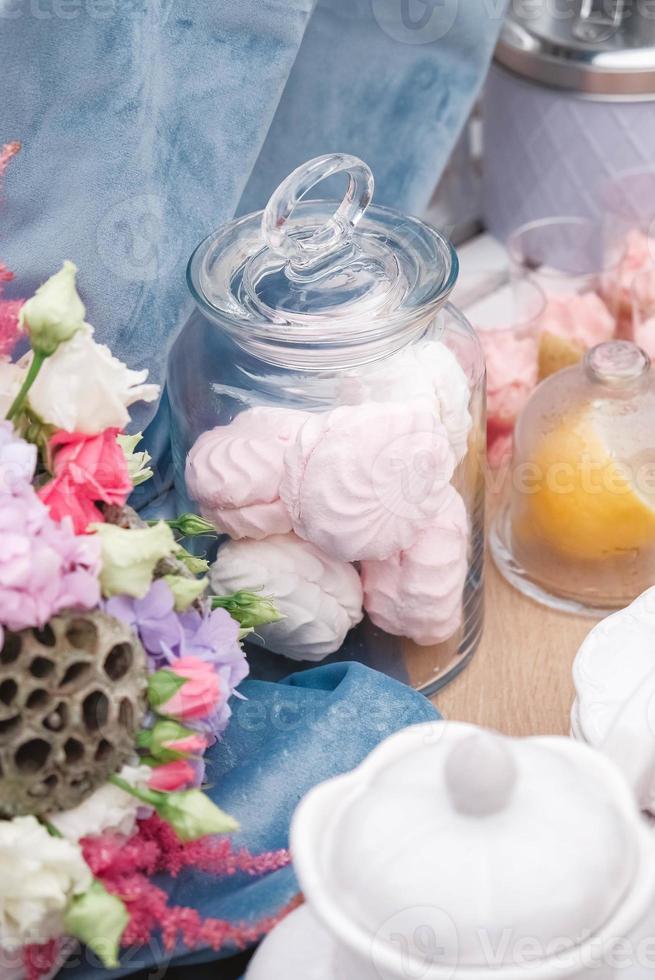 Wedding candy bar in rustic style decorated with plates, cutlery, glasses, candles and flower arrangements. Copy, empty space for text photo