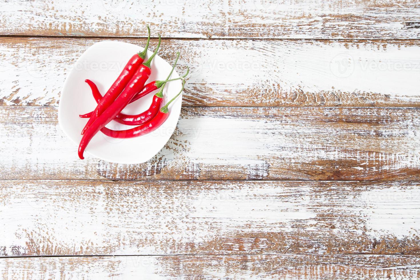 Decoration of red hot chili pepper on wodden board. Set,copy space,mock up. Cayenne on white plate photo