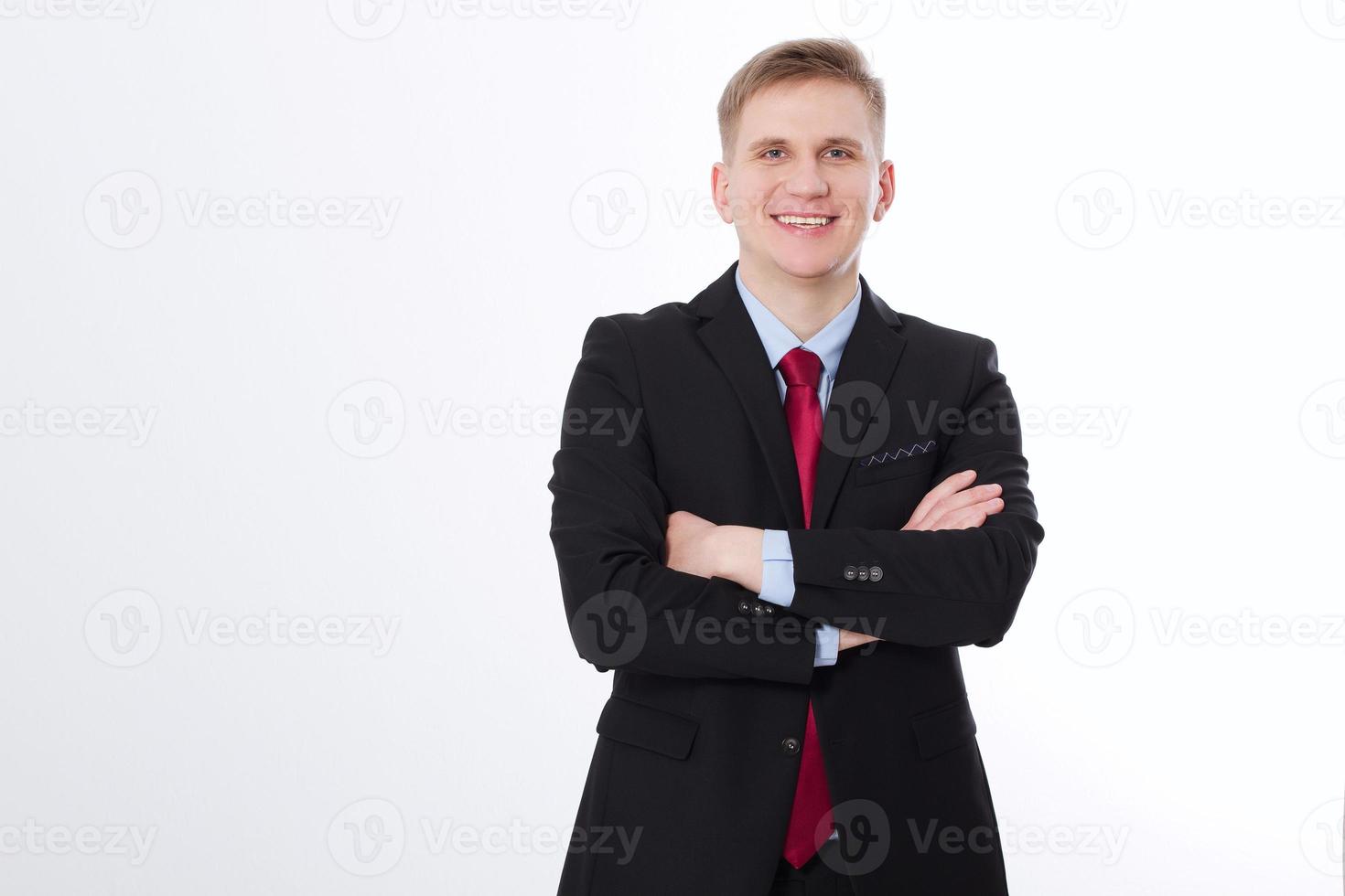 Portrait of happy smiling young businessman with crossed hands isolated on white background. Copy space and mock up. Business concept photo