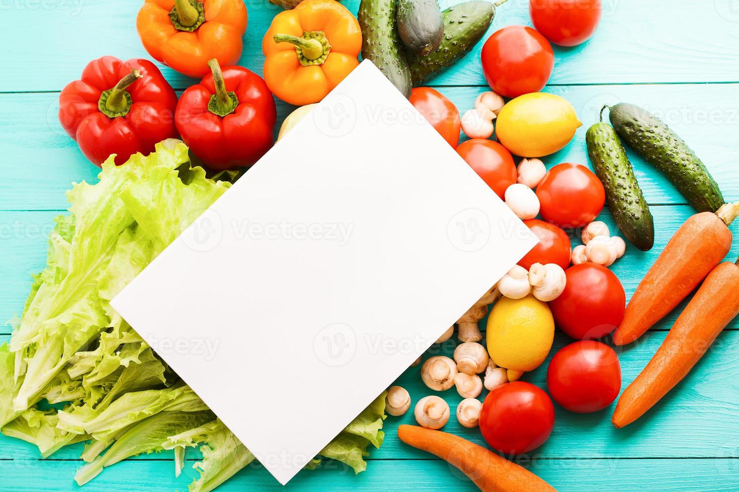 Different vegetables on kitchen table with recipe list and copy space. Top view photo