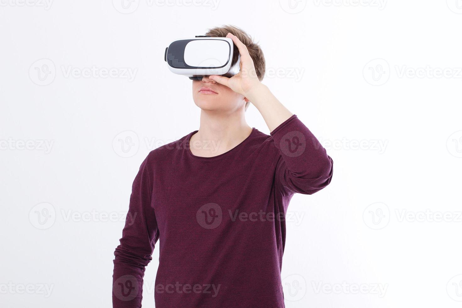 Portrait of young man wearing virtual reality goggles isolated on white background. Copy space and mock up. Smartphone and VR headset. Horizontal image photo