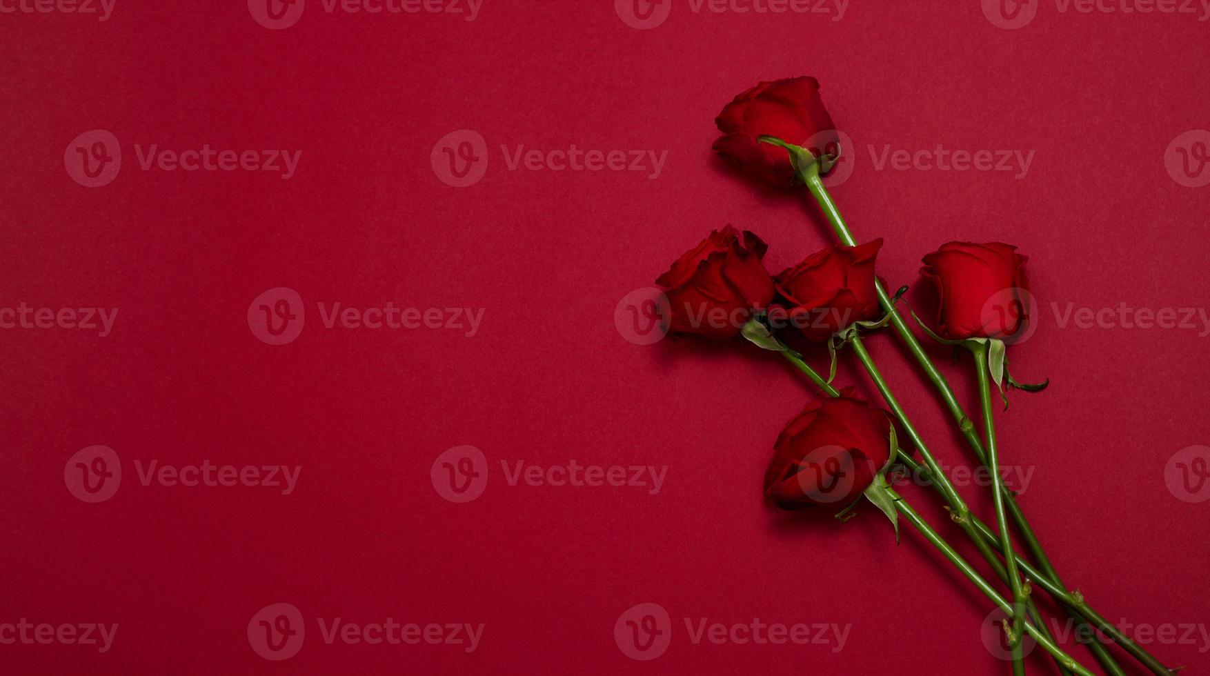 Send flowers online concept. Flower delivery for valentine and mother day. Bouquet of red roses isolated on red background. Post card design with beautiful nature rose. Top view. copy space. photo