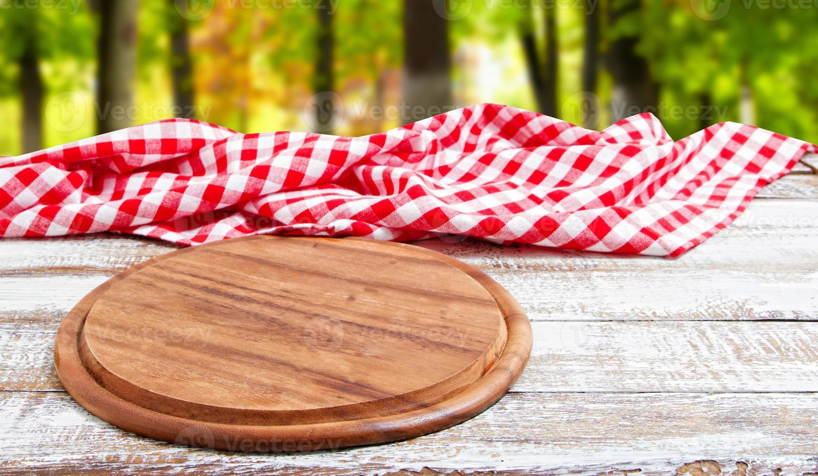 empty pizza board on empty wooden table with tablecloth,napkin - top view photo