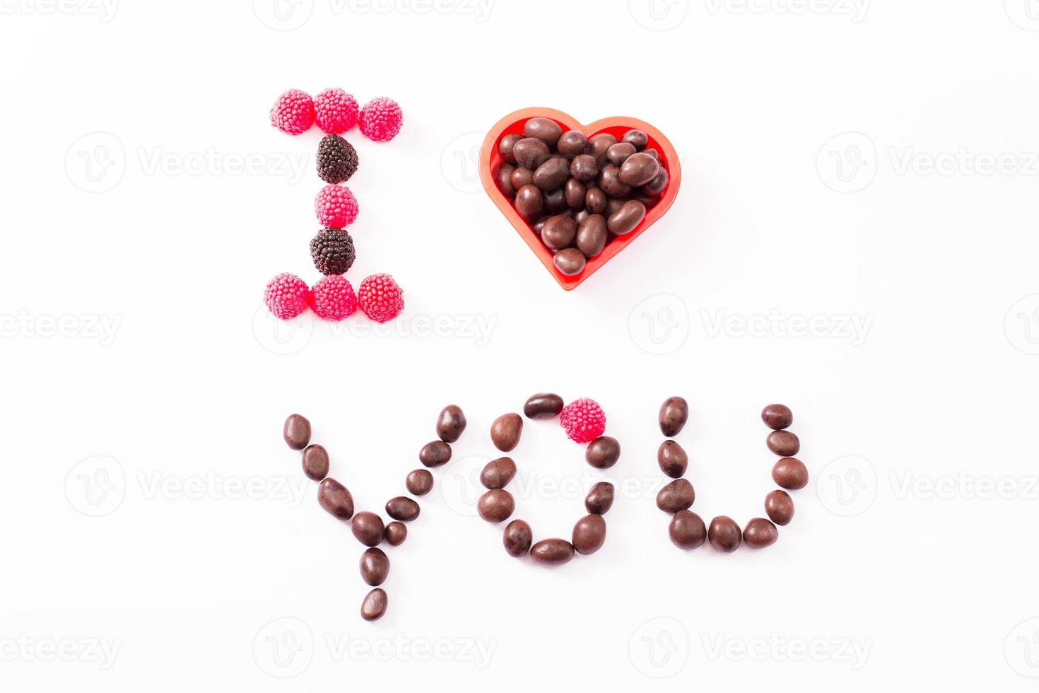 Candy and sweets isolated on white background. Heart shape. Top view. Selective focus. Copy space and mock up photo