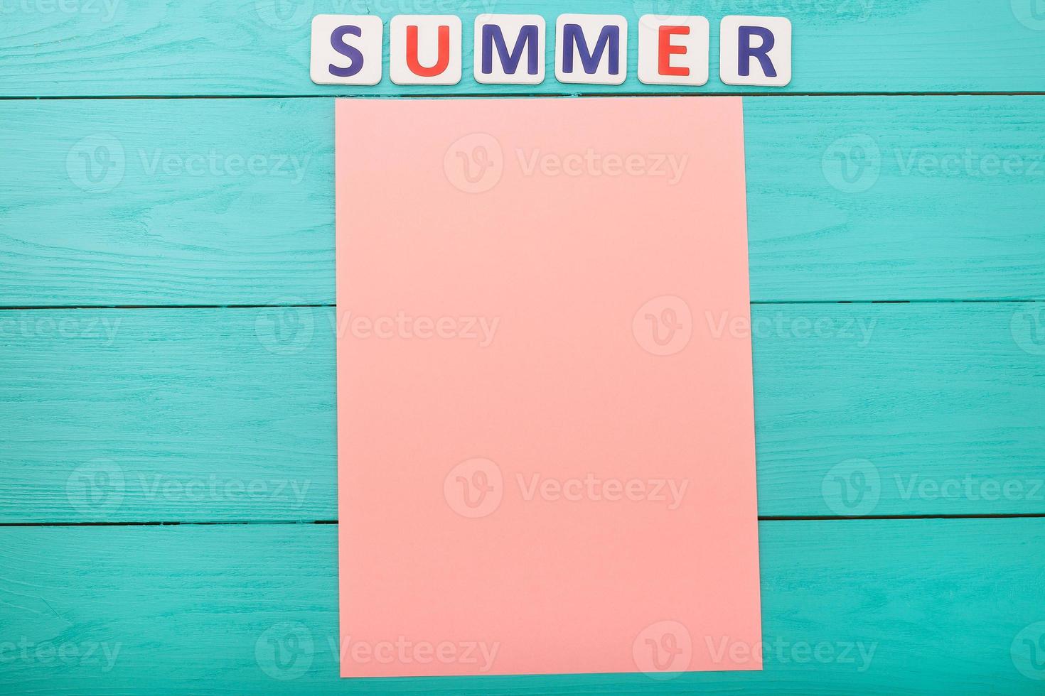 Word summer and paper with copy space on blue wooden background photo