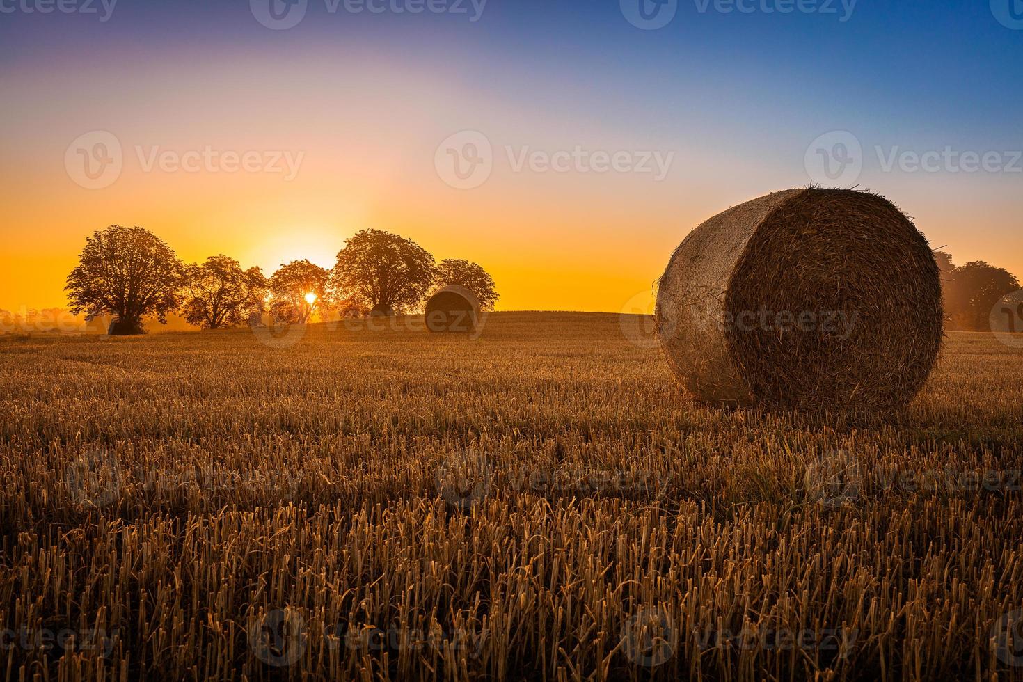 Haystack in Denmark with the sun setting behind photo