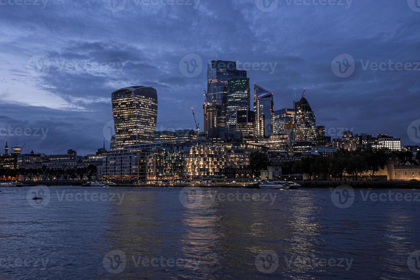 vista de los modernos rascacielos iluminados del distrito financiero desde el río Támesis foto