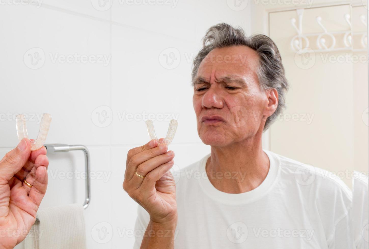 Man Putting in his Night Guard in Front of a Mirror photo