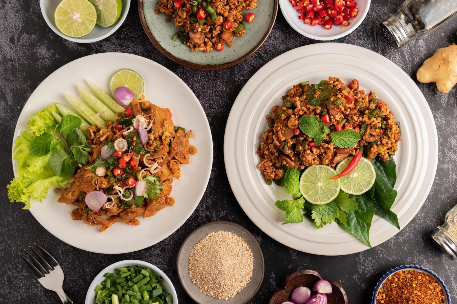 Spicy minced pork salad with chili flakes, lime, chopped green onions, chili and roasted rice. photo