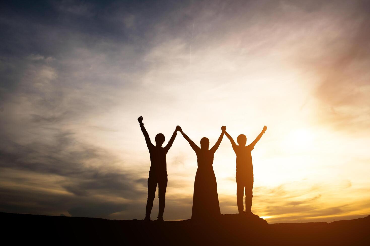 silueta de madre con su hija de pie y puesta de sol foto