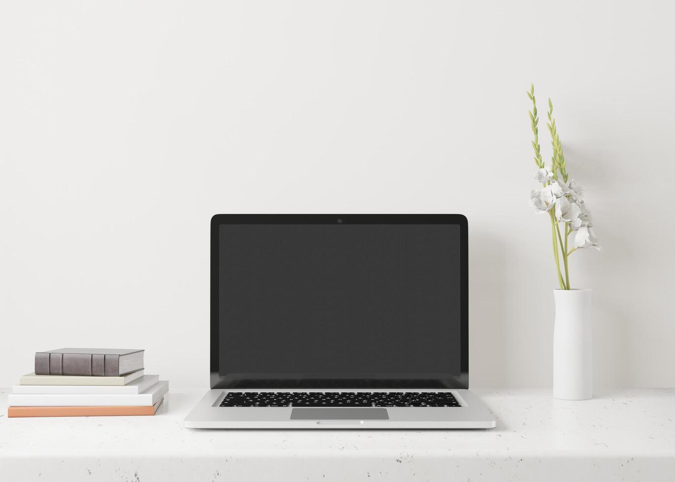 A laptop with a flower vase on the table photo