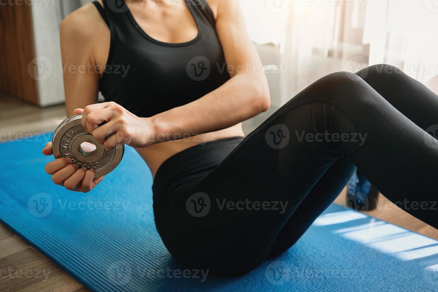 mujer decidida a perder peso en casa y hacer ejercicio con pesas. concepto de deporte y recreación. foto