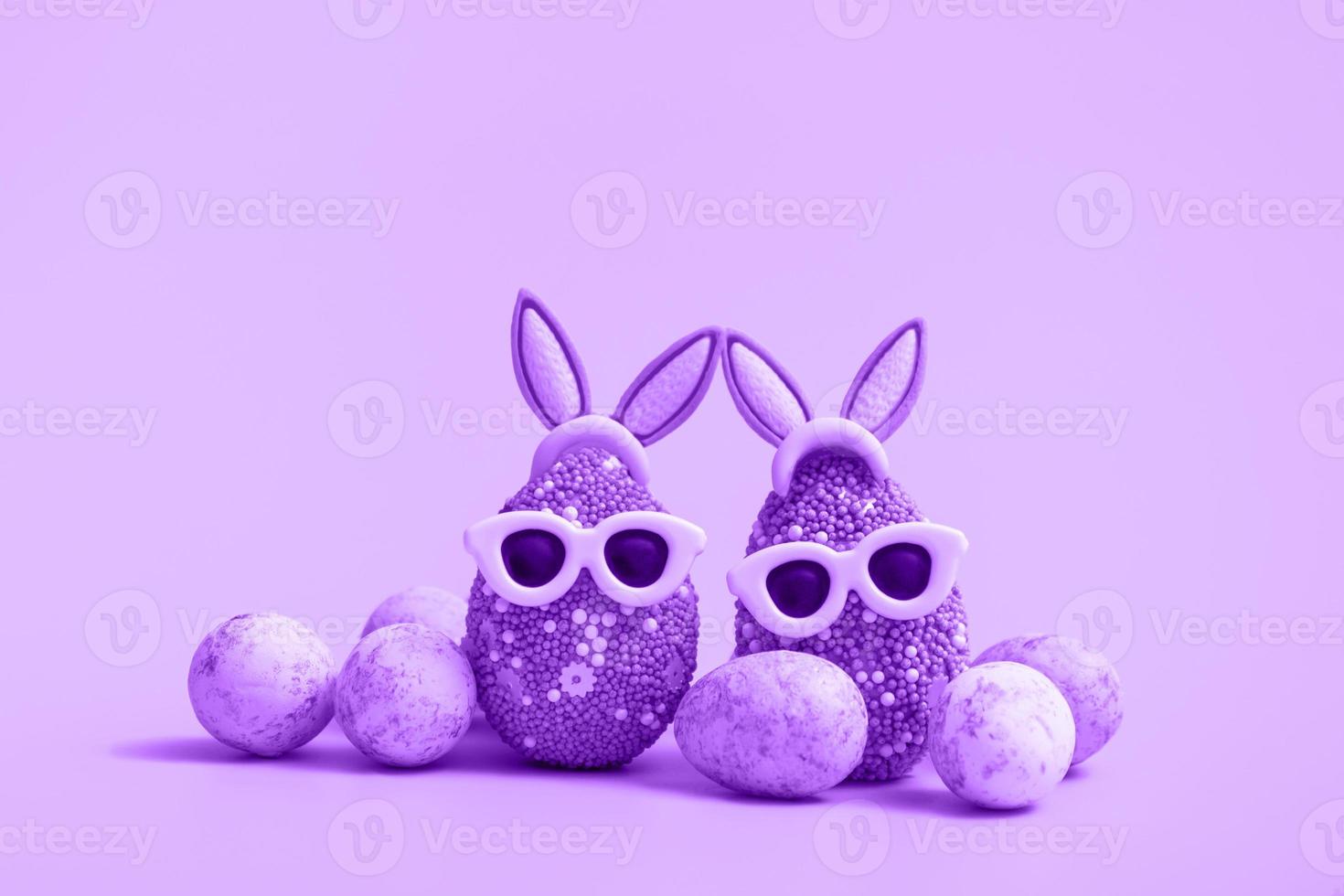 huevo de Pascua colorido con orejas de conejo y gafas de sol sobre un fondo violeta. banner de venta, plantilla de maqueta. copie el espacio foto