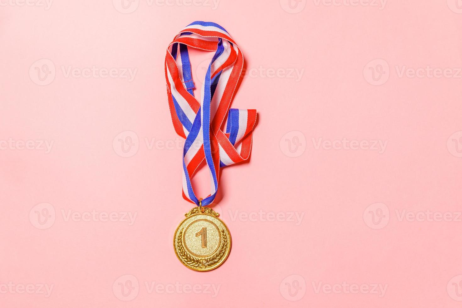 Simply flat lay design winner or champion gold trophy medal isolated on pink colorful background. Victory first place of competition. Winning or success concept. Top view copy space. photo