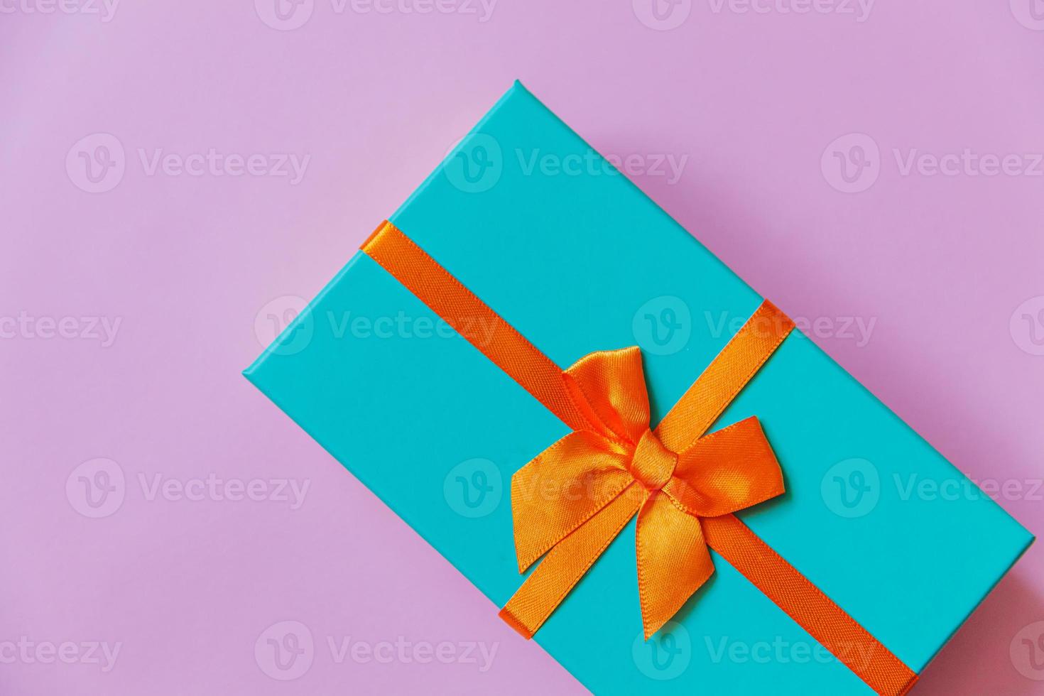 Christmas New Year birthday valentine celebration present romantic concept. Simply minimal design blue gift box isolated on violet purple colorful background. Flat lay top view, copy space photo