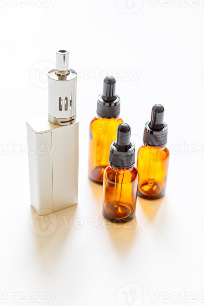 Vaping device e-cigarette electronic cigarette and liquid bottles isolated on white background. Vape device for alternative smoking. Vaping shop concept. Gadget for vaper. Vaping accessories. photo