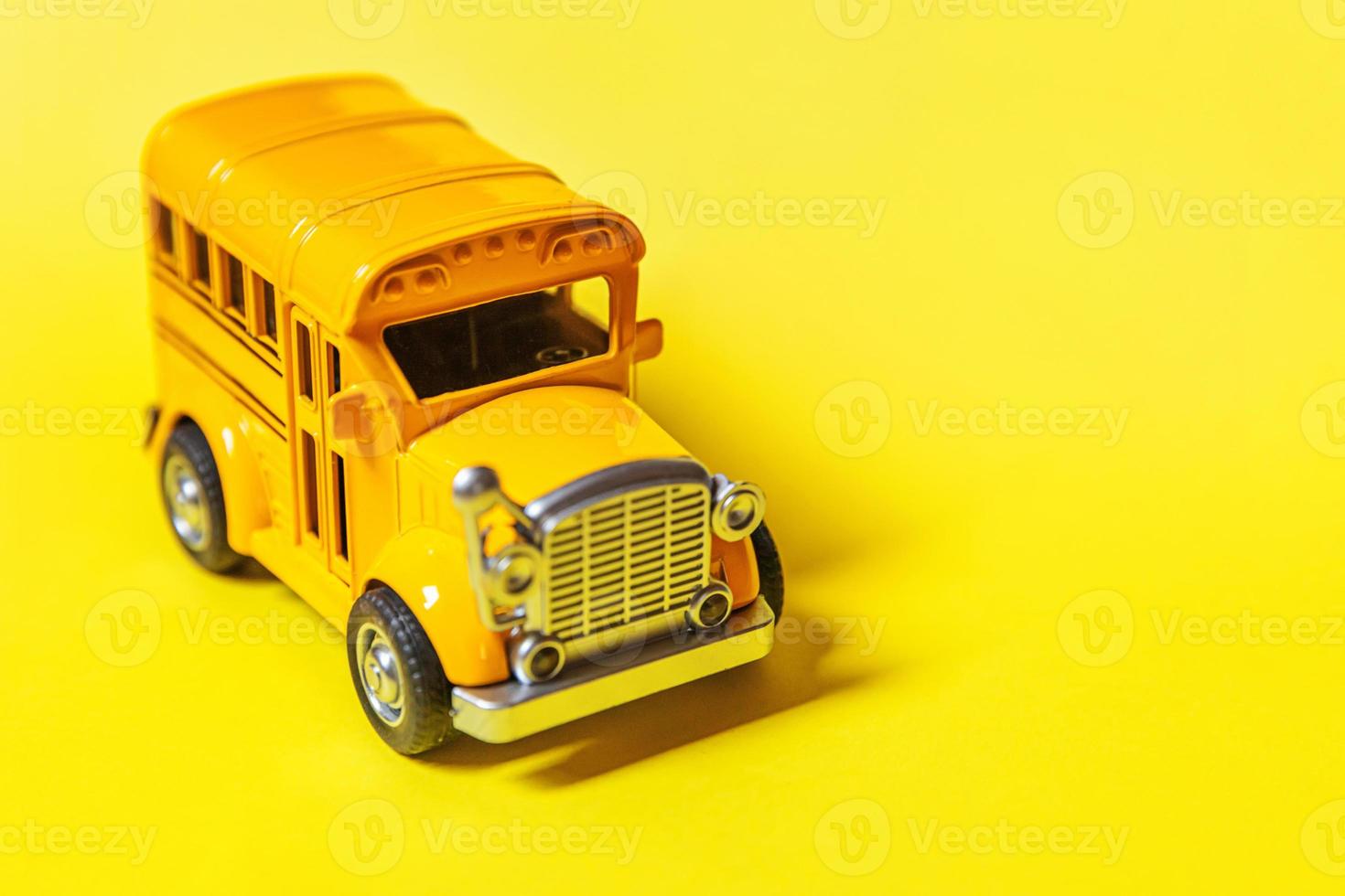 Simply design yellow classic toy car school bus isolated on yellow colorful background. Safety daily transport for kids. Back to school concept. Education symbol, copy space photo