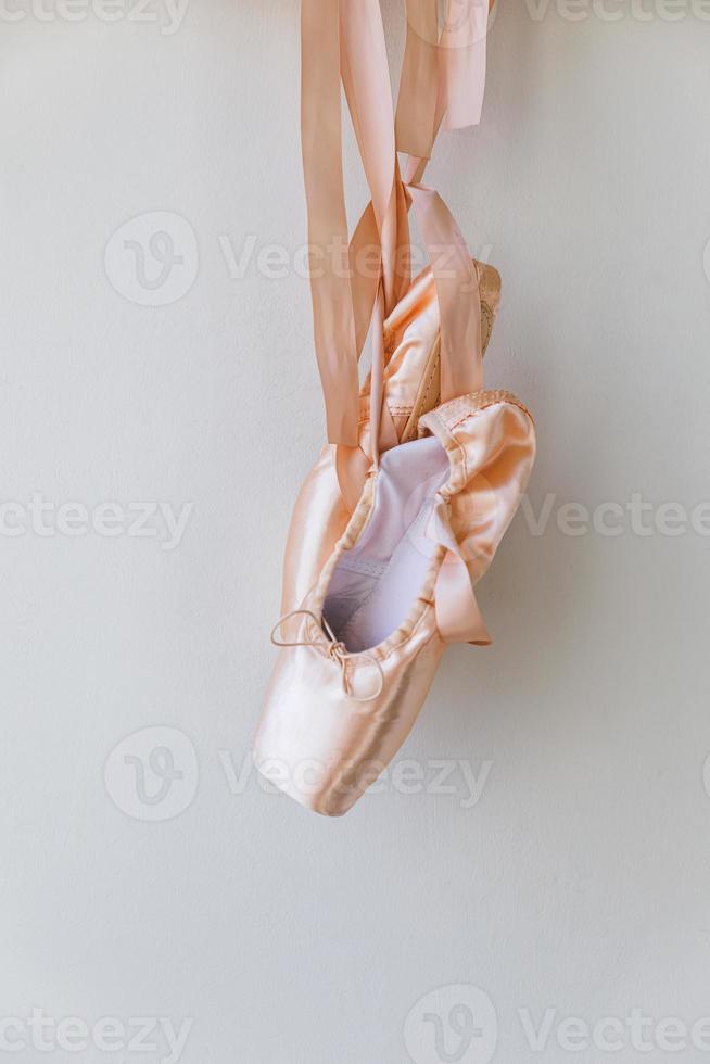 New pastel beige ballet shoes with satin ribbon isolated on white background. Ballerina classical pointe shoes for dance training. Ballet school concept, Copy space photo
