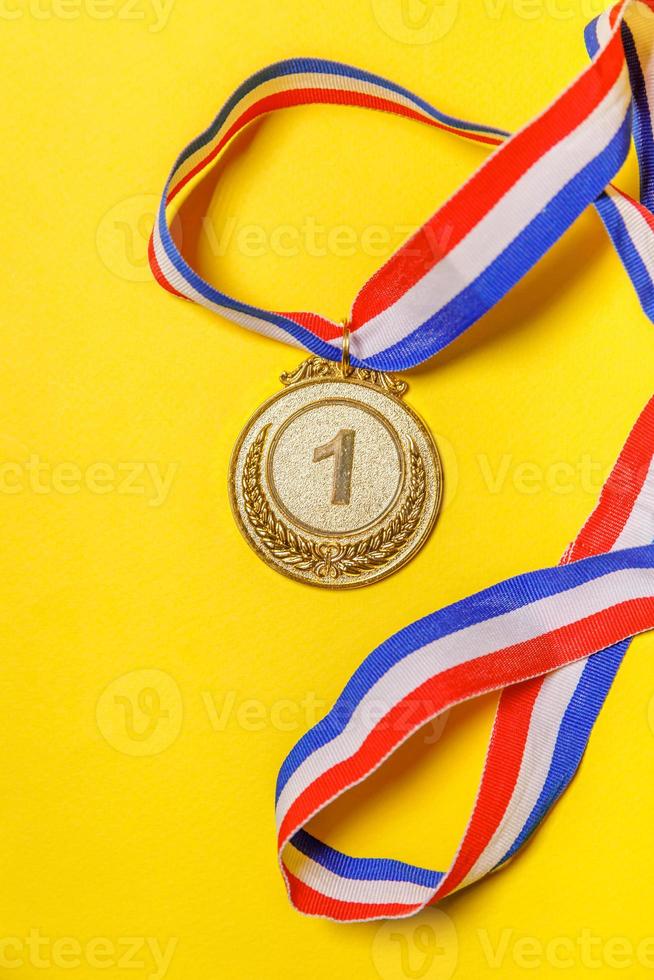 ganador de diseño simplemente plano o medalla de trofeo de oro campeón aislada en un fondo de color amarillo. victoria primer lugar de la competencia. concepto ganador o de éxito. vista superior. foto